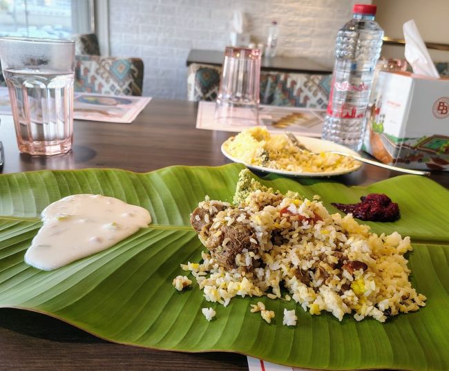 Kerala beef biryani and side dishes served on a banana leaf at Beypore Boat restaurant, Madinat Zayed, Abu Dhabi